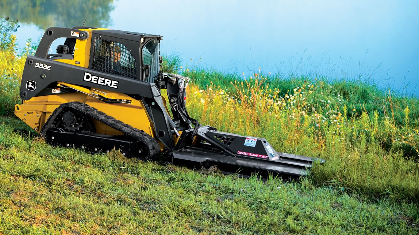 John Deere Skid Steer with Rotary Cutter Attachments cutting tall grass.